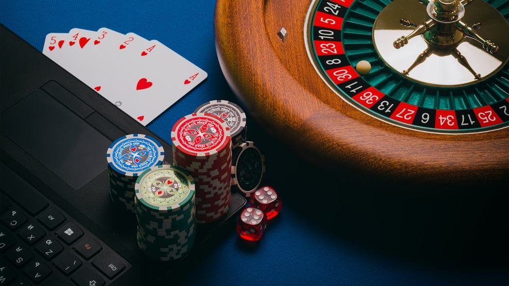 Roda roulette dan chip poker di meja kasino langsung